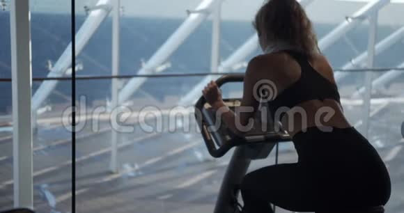 健身房里的女人骑着运动自行车视频的预览图