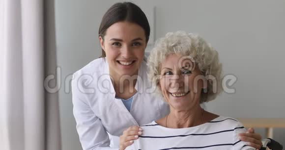 微笑着年轻的医务工作者拥抱着快乐的70年代养老金领取者的肩膀视频的预览图