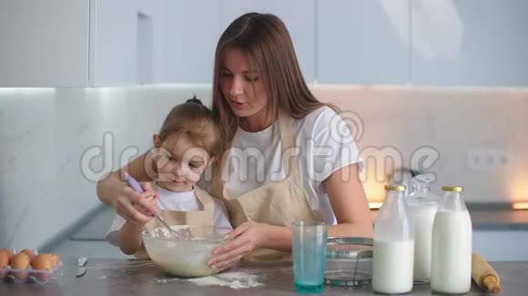 嘲笑妈妈和女儿在厨房做饭这个女孩向她母亲学习如何做馅饼快乐的童年视频的预览图