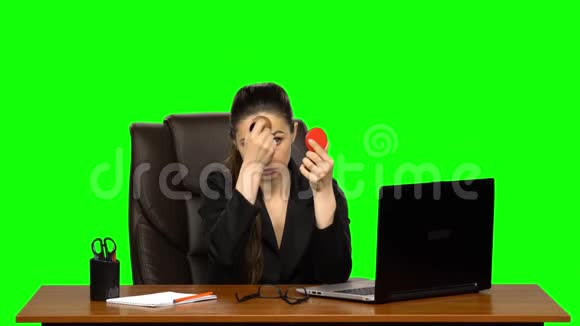 工作场所的女商人化妆在脸上涂粉照着红镜子绿色屏幕视频的预览图