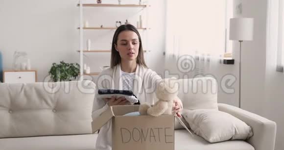 快乐女义工包装儿童捐款箱看镜头视频的预览图