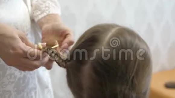 妈妈害怕她的小女儿母亲用梳子梳孩子头发美丽发型的概念视频的预览图