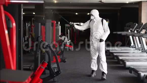 危险物质工人用抗菌消毒喷雾器消毒冠状病毒covid19危害中的健身器材视频的预览图