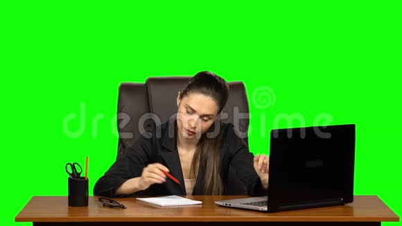 漂亮的女人坐在工作场所拿着笔记本和铅笔努力思考烦躁地叹息滚动她的眼睛绿色视频的预览图
