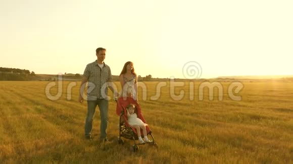 在大自然中和一个小孩子在婴儿车里散步小女儿坐在公园里的一辆有轨电车上背景是太阳视频的预览图
