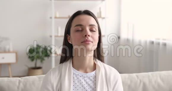 冷静的年轻女子闭着眼睛沉思着呼吸视频的预览图