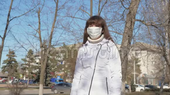 一个戴着防毒面具的女孩站在街上大流行冠状病毒健康和安全概念视频的预览图