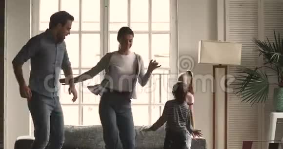 幸福的年轻夫妇和孩子们一起跳舞视频的预览图