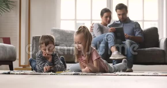 小孩子在父母使用数码平板电脑时画画视频的预览图