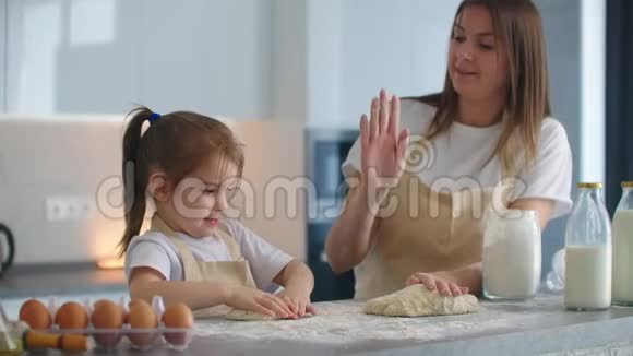 妈妈和女儿在厨房里做饭给了五个洋葱打掉五个拍手烹饪视频的预览图