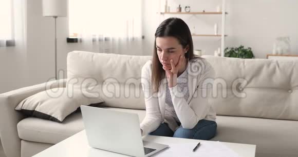 关注千禧一代女孩使用笔记本电脑在家做研究视频的预览图