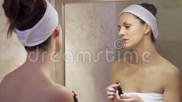 漂亮的年轻女人涂红口红照镜子视频的预览图