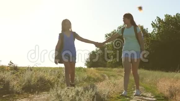 夏天公园里快乐的徒步旅行者女孩自由的女人手拉手女孩在乡下的路上旅行女旅客视频的预览图