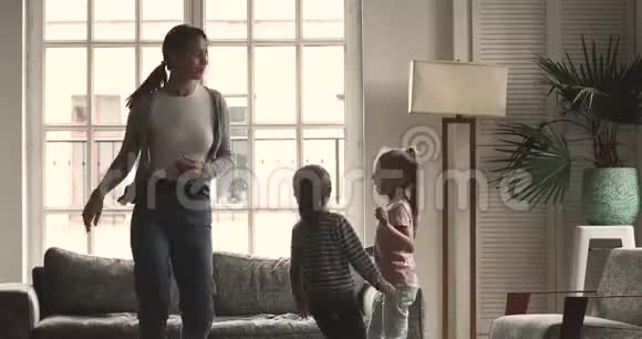 活泼的年轻妈妈保姆和可爱的孩子跳舞视频的预览图