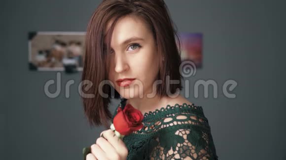 红玫瑰花的女孩正沉思地看着镜头情人节二月十四日生日周年纪念日第一天视频的预览图