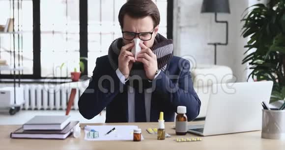 生病的办公室职员坐在工作场所用药吹鼻子视频的预览图