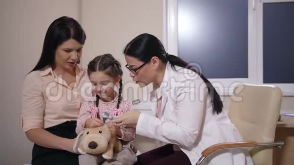 医生检查玩具狗和小孩的耳朵视频的预览图