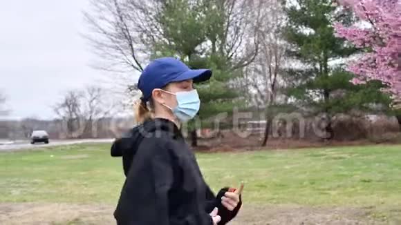 一位戴着空气污染防护面罩的妇女正在春天的户外跑步视频的预览图