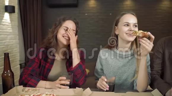 一群吃比萨饼的朋友在家里的客厅里一起谈笑风生视频的预览图