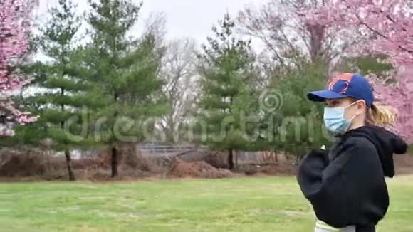 一位戴着空气污染防护面罩的妇女正在春天的户外跑步视频的预览图