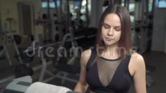 一位健身妇女在健身房跑步机上做有氧训练的肖像健身中心的运动女孩使用跑步机视频的预览图