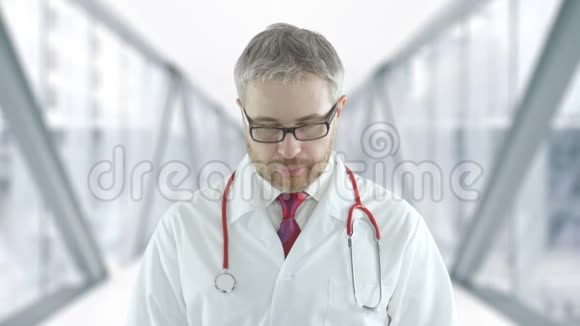 医院玻璃走廊里一位自信微笑的医生的画像视频的预览图