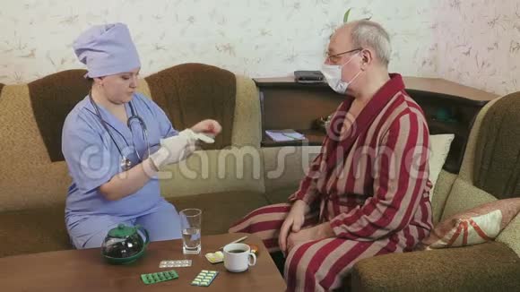 一位女医生正准备在家检查一位病人戴上手套视频的预览图