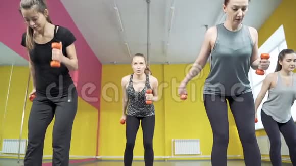 一群年轻女性在健身俱乐部和哑铃一起工作健康生活方式视频的预览图