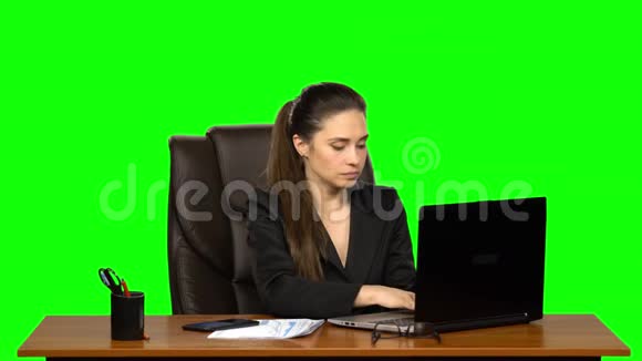 在笔记本电脑上工作的女人然后用手机接电话看文件时很惊讶很高兴绿色视频的预览图