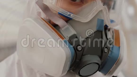 关闭病毒学家工作人员的防护服护目镜和呼吸器视频的预览图