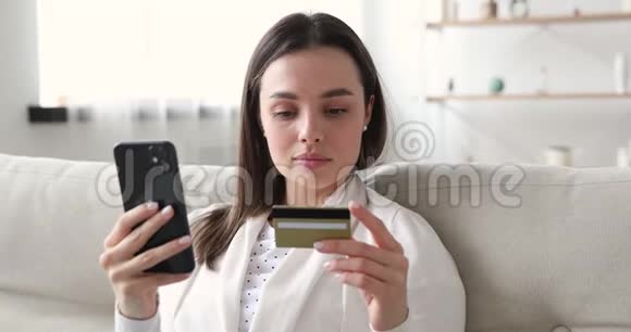 微笑的女性消费者在智能手机上用信用卡购物视频的预览图