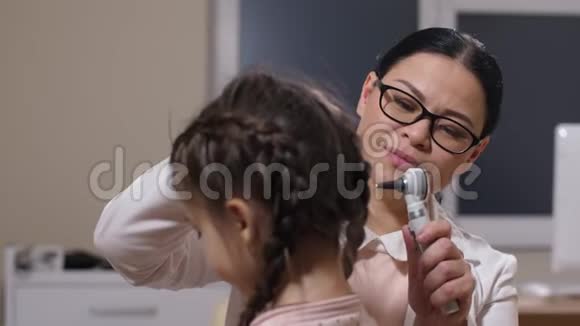 女性耳鼻喉科医生检查生病女孩的耳朵视频的预览图