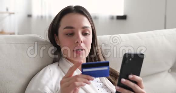 使用移动支付方式持有信用卡的快乐年轻女性视频的预览图