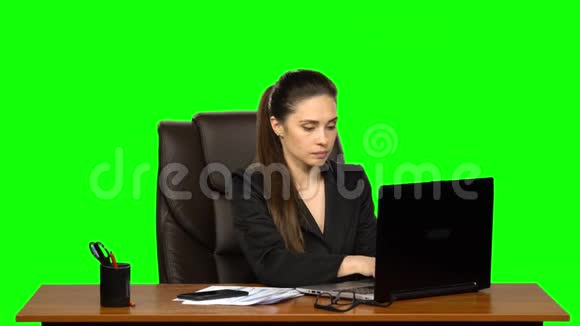女人在笔记本电脑上工作然后接电话的手机电话惊讶和非常高兴绿色屏幕视频的预览图