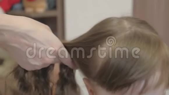 女儿美丽发型的概念母亲用梳子梳孩子头发一个幸福的家庭妈妈害怕视频的预览图