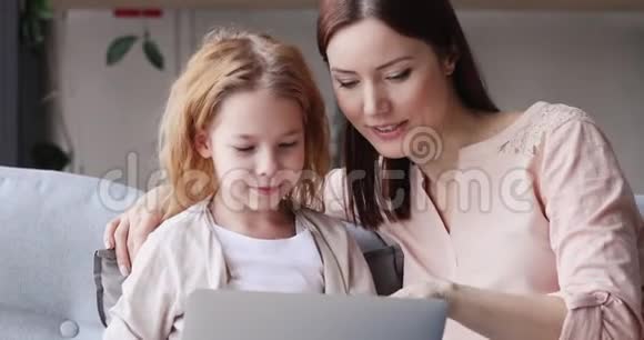使用家长控制的笔记本电脑学习快乐的女孩子视频的预览图
