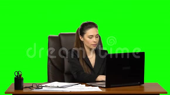 女经理在笔记本电脑上工作思考做笔记然后微笑与快乐绿色屏幕背景视频的预览图