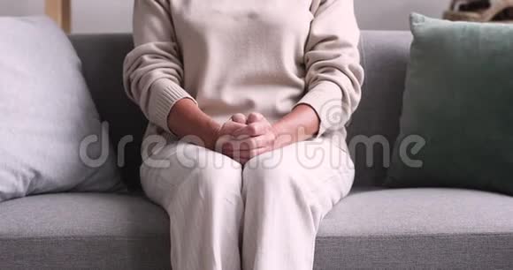 被遗弃的孤独的老太太双手交叉坐在沙发上视频的预览图