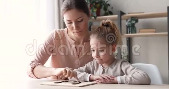 聪明的女学生和妈妈玩游戏视频的预览图