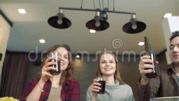一群朋友在聚会上举起瓶子和叮当作响的眼镜青年和假日的概念视频的预览图