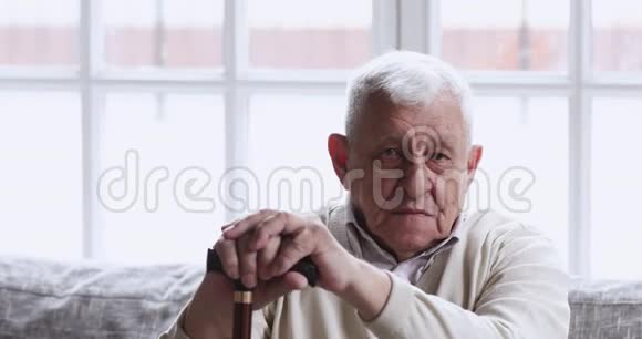 快乐的老人拿着手杖看着摄像机视频的预览图