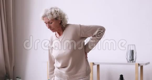 疲惫的老妇人感到突然的背痛视频的预览图
