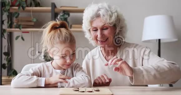快乐的两代人一家人在餐桌上玩单调游戏视频的预览图