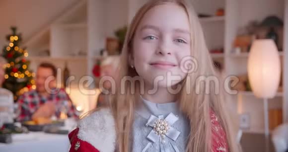 一位金发碧眼的小女孩圣诞背景家庭微笑的肖像视频的预览图