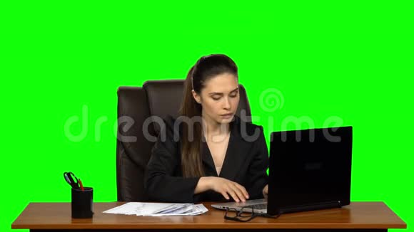 在笔记本电脑上工作的女孩突然开始在桌子上寻找文件当她发现时她很高兴绿色屏幕视频的预览图