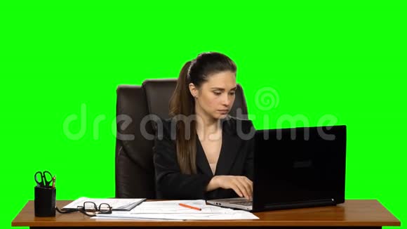 女经理在笔记本电脑上工作并做笔记绿色屏幕背景视频的预览图