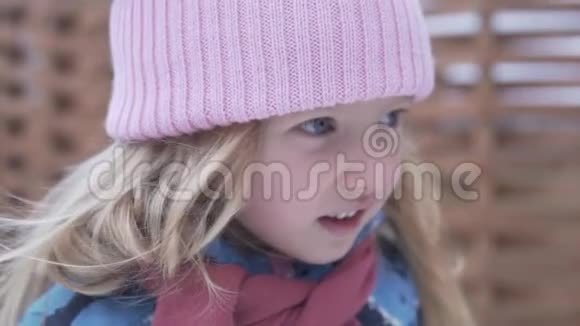 穿着粉红色帽子的有趣的小女孩在春天走在外面视频的预览图