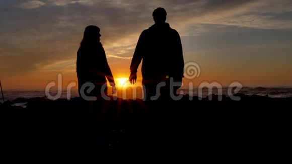 慢动作冠军夫妇携手并在背景阳光在日落时牵手太阳光芒视频的预览图