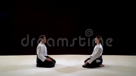 两个大师武术合气道互相鞠躬拍摄在黑白背景上视频的预览图