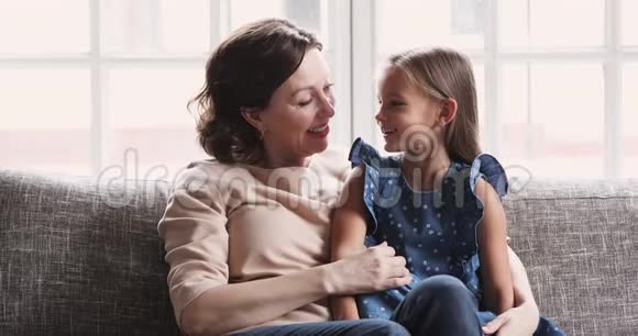 可爱的孙女和成熟的祖母在家交谈视频的预览图